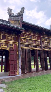 Vietnam 'ın başkenti Hue' da tarihi saray dış cephesi, süslü ahşap kapılar, geleneksel imparatorluk mimarisi ve dekoratif ayrıntılar, Vietnam kültürü ve mirası sergileniyor.