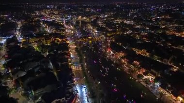 Gece vakti Hoi An Eski Kasabası 'nın parlayan fener teknelerinin nehir boyunca hareket ettiği canlı şehir ışıkları ve Vietnam' da Vietnam kültürünü ve gece hayatını gözler önüne seren hareketli caddeler..