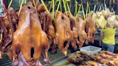 Bangkok, Tayland 'daki geleneksel Asya sokak pazarında asılı duran kızarmış ördekler. Yerel gıda ambarında popüler Çin mutfağı spesiyali sergileniyor.