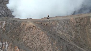 Endonezya 'daki Bromo Dağı volkan kraterinin kenarında yürüyen kadının hava görüntüsü. Doğa kavramı, seyahat, macera ve nefes kesici manzaralar..