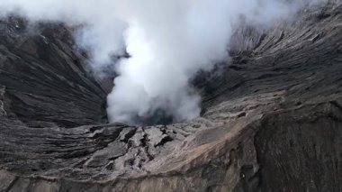 Doğu Java, Endonezya 'daki Bromo Dağı' nın havadan görünüşü. Kalderadan yükselen kalın volkanik buharla. Doğa, seyahat, jeoloji ve dramatik manzaralar için mükemmel..