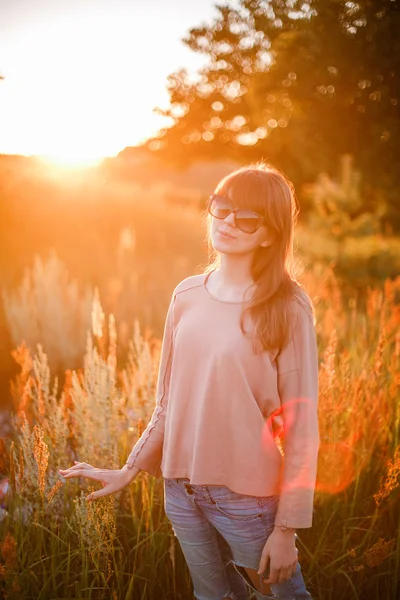 Jovem menina moderna no fundo por do sol . — Fotografia de Stock