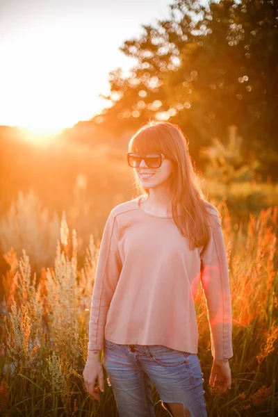 Jovem menina moderna no fundo por do sol . — Fotografia de Stock