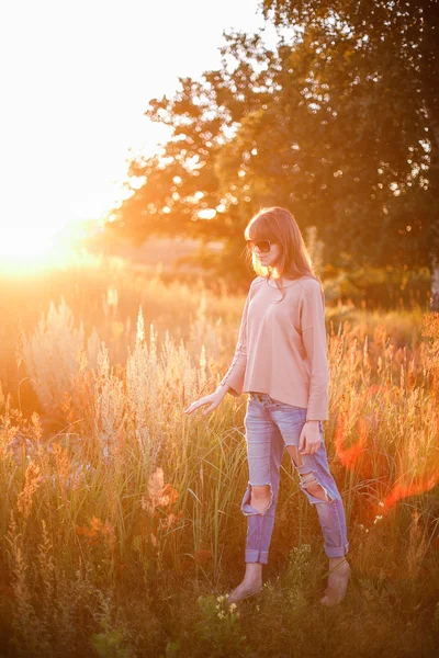 Jovem menina moderna no fundo por do sol . — Fotografia de Stock