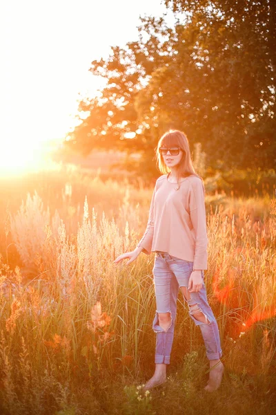 Junges modernes Mädchen auf dem Hintergrund Sonnenuntergang. — Stockfoto