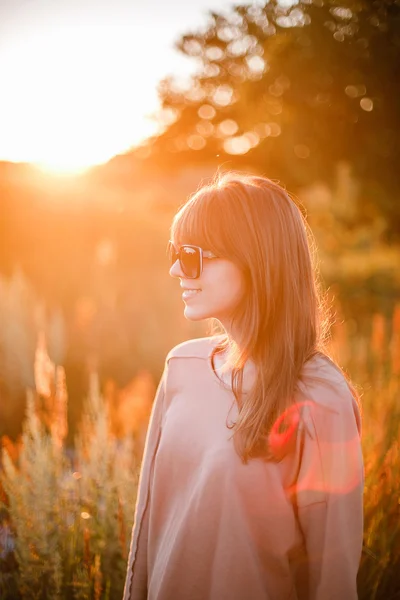 Jovem menina moderna no fundo por do sol . — Fotografia de Stock