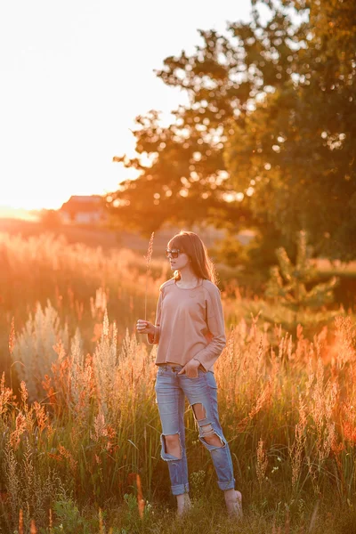 Junges modernes Mädchen auf dem Hintergrund Sonnenuntergang. — Stockfoto