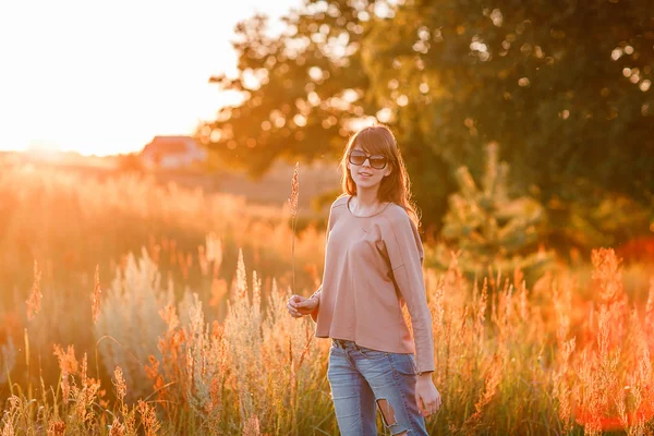 Jovem menina moderna no fundo por do sol . — Fotografia de Stock