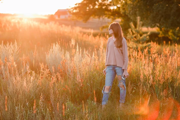 Young modern girl on background sunset. — Stock Photo, Image