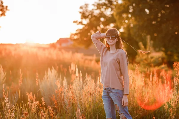 Jovem menina moderna no fundo por do sol . — Fotografia de Stock