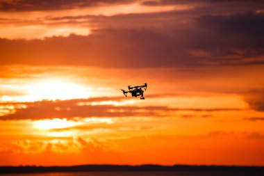 Uzaktan kumanda ile quadrocopter dron. Karanlık siluet Derma günbatımı karşı. Yumuşak odak. Tonlu görüntü