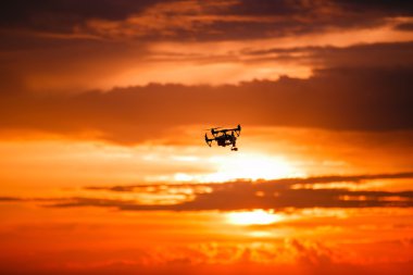 Uzaktan kumanda ile quadrocopter dron. Karanlık siluet Derma günbatımı karşı. Yumuşak odak. Tonlu görüntü