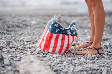 girl stand in the beach. Usa flag bag clipart