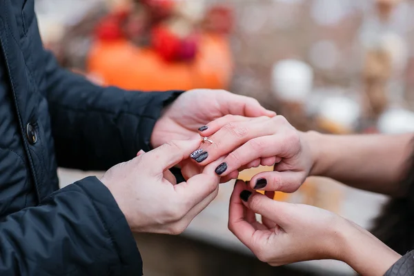 Gambar pria yang memasang cincin perak di tangan wanita, di luar ruangan. Hutan musim gugur — Stok Foto
