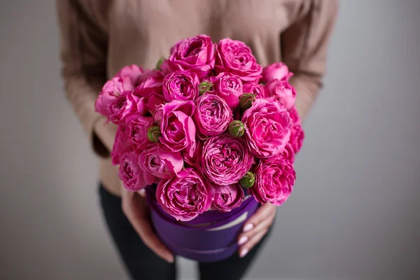 Rico ramo de flores de eustoma rosa y rosas, hoja verde en la mano Ramo de primavera fresca. Fondo de verano. caja de sombreros composición — Foto de Stock