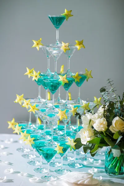 A pirâmide de copos com champanhe e uma carambola — Fotografia de Stock