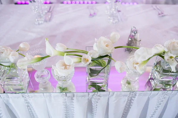 Hermosa decoración de mesa interior de restaurante para boda. Flor. Nenúfares blancos y tulipanes en jarrones. Velas —  Fotos de Stock