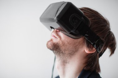 Gri bir arka plan üzerinde izole sanal gerçeklik gözlük takan yakışıklı adam