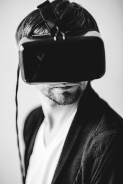 Gri bir arka plan üzerinde izole sanal gerçeklik gözlük takan yakışıklı adam