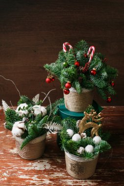 Noel çiçek çelenk dekorasyon meşe arka plan üzerinde baubles, kırmızı yay, holly ve kış yeşillikler ile.