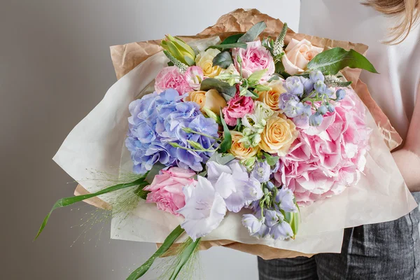 Florista no trabalho. Faça serenidade hortênsia rico buquê. flores em suas mãos — Fotografia de Stock