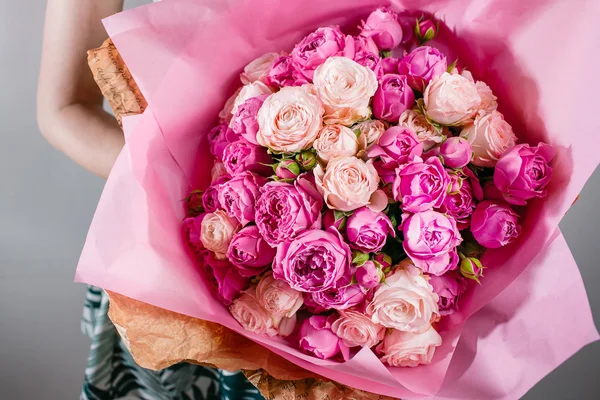 Luxus csokrok virágok rózsaszín pünkösdi rózsa és a rózsa a kezek nők. — Stock Fotó