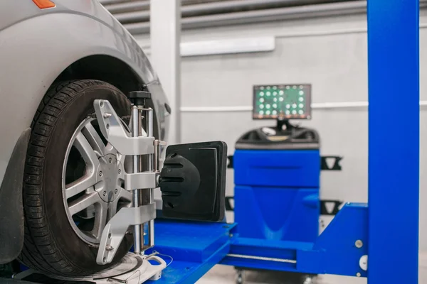 Coche en pedestal con ruedas sensores para alineamiento camber verificación en taller de estación de servicio. — Foto de Stock