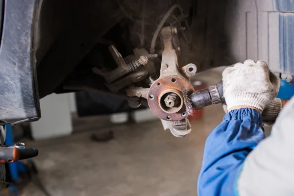 Disco de freio novinho em folha no carro em uma garagem. Auto reparação mecânica  . — Fotografia de Stock