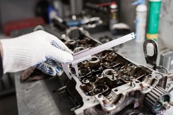 Mecânico, usando um paquímetro, para verificar a espessura. Completo motor grandes reparos. Casa de banho de hardware . — Fotografia de Stock