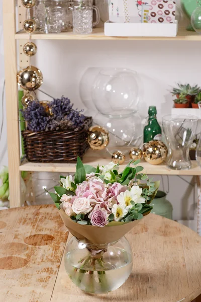 Γυάλινο βάζο με μικτή μπουκέτο σε τραπέζι από ξύλο. όμορφα φρέσκα λουλούδια ακόμα ζωή. — Φωτογραφία Αρχείου