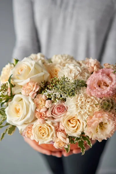 Blumengesteck in Kürbis auf dem weißen Tisch. Frische Schnittblumen zur Dekoration nach Hause. Europäischer Blumenladen. Lieferung frischer Schnittblumen. — Stockfoto