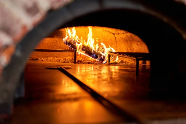 Traditional wood oven in Naples restaurant, Italy. Original neapolitan pizza. Red hot coal. Baked tasty pizza