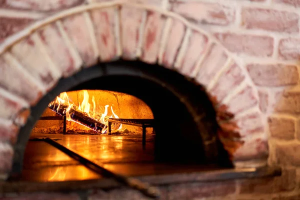 Traditional wood oven in Naples restaurant, Italy. Original neapolitan pizza. Red hot coal. Baked tasty pizza