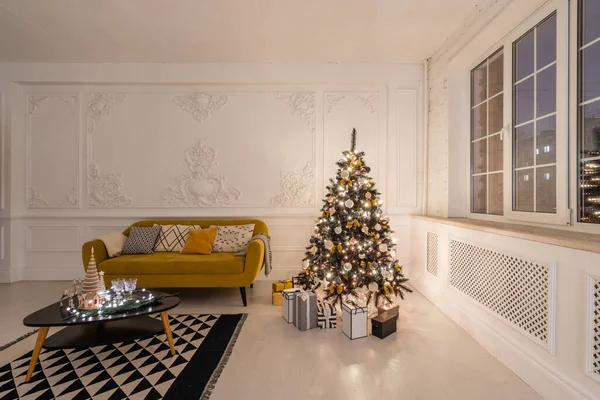 Apartamentos clásicos con árbol de Navidad decorado y regalos. Noche de Navidad a la luz de velas y guirnaldas. Vivir con chimenea y estuco. — Foto de Stock