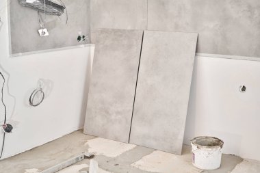 Çatı katı tarzında büyük seramik fayanslar, beton. Evdeki yemek odasının tamiri, mutfak yeri, zemin kaplaması. Tasarım için içi boş, gri beton duvar.