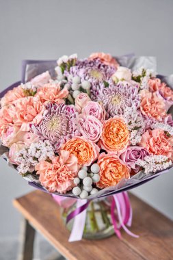 Ahşap masada güzel bir buket karışık çiçek. Çiçekçi dükkanındaki çiçekçinin işi. Taze kesilmiş çiçek getirdim. Avrupa Çiçek Dükkanı.