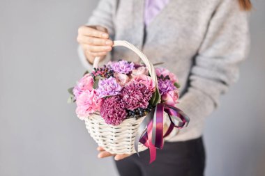 Wicker sepetinde çiçek aranjmanı. Kadın elinde güzel bir buket karışık çiçek. Güzel, taze bir buket. Küçük çiçekçi ve çiçek teslimatı..