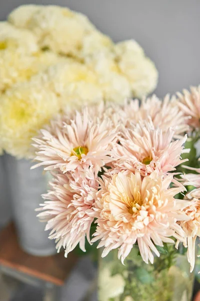 Mono bouquet of chrysanthemum in metal vase. European floral shop. the work of the florist at a flower shop. Delivery fresh cut flower.