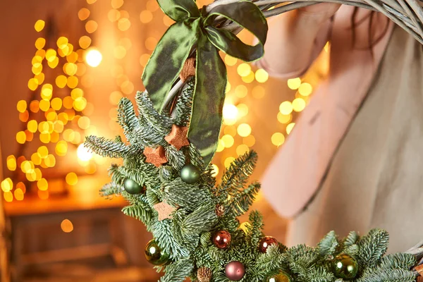 Jonge vrouw met een kerstkrans lus versierd sparren takken en kerstspeelgoed voor de vakantie. Het nieuwjaarsfeest. Europese bloemenwinkel — Stockfoto