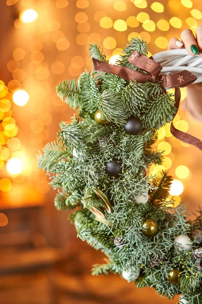 Jonge vrouw met een kerstkrans lus versierd sparren takken en kerstspeelgoed voor de vakantie. Het nieuwjaarsfeest. Europese bloemenwinkel — Stockfoto