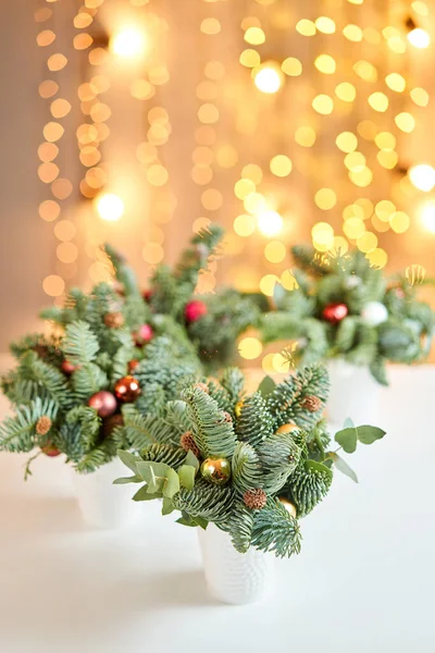 Arranjo de Natal com pinheiro norueguês Nobilis e decorado com decoração de Natal em uma taça de cerâmica. Garland bokeh no fundo. Amor de Natal. Mesa de madeira escura polvilhada com neve — Fotografia de Stock