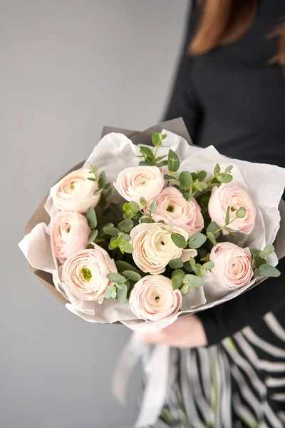 Mazzo di fiori ranuncoli rosa pallido con eucalipto verde. Il lavoro del fioraio in un negozio di fiori. — Foto Stock