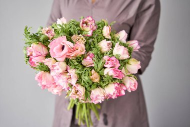 Güzel bir buket pembe şakayık kadın elinde. Çiçekçi dükkanındaki çiçekçinin işi. Küçük bir aile şirketi.