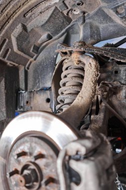 Şok emici, yay ve dengeleyici çubukları el feneriyle inceliyor. Tamirhanedeki araba. Araba için teknik servis istasyonu.