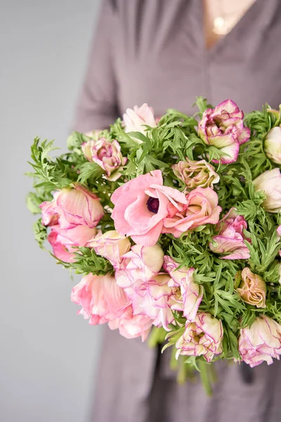 Belo buquê de anêmonas rosa na mão da mulher. o trabalho da florista em uma loja de flores. Uma pequena empresa familiar — Fotografia de Stock