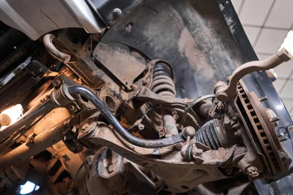 Inspecte la suspension, les pièces de direction, les extrémités des bielles. Voiture sur un stand de réparation. Station service technique pour voiture. — Photo