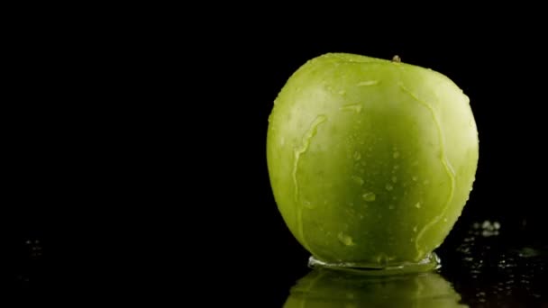 Water spatten over groene appel in slow motion — Stockvideo