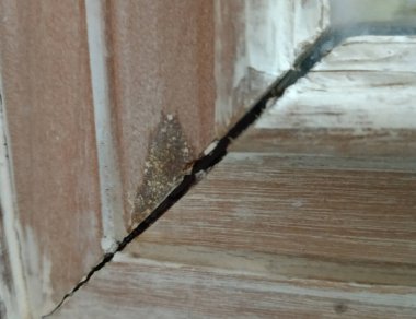 Kırık çatılı, ahşap arka planlı eski pencereyi kapat..