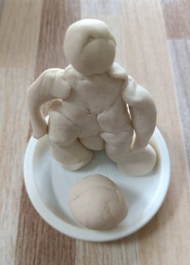 Ahşap masanın arkasında siyah beyaz maskeli beyaz bir adam.