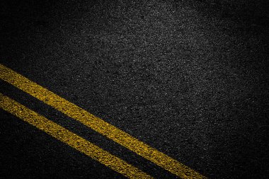 Asfalt yolundaki beyaz ve sarı çizgiler.
